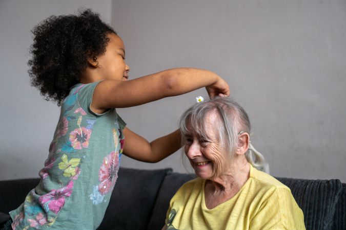 Older woman having her hair done by grandchild