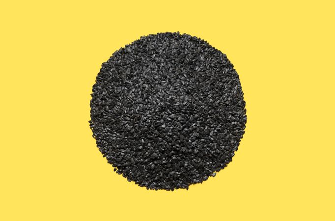 Pile of sunflower seeds isolated on a yellow background