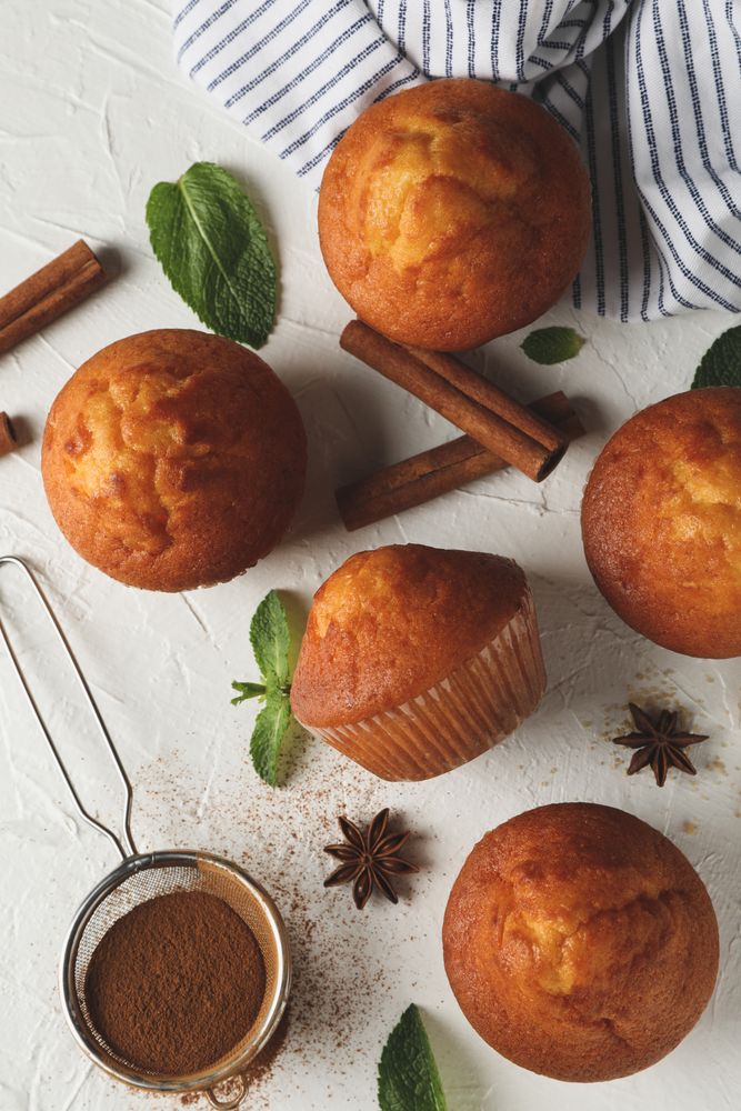 Composition with muffins and cinnamon on light background