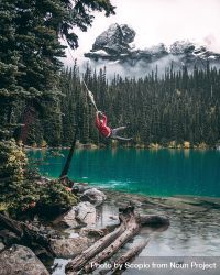 Man swinging rope and jumping in lake 4Mvekb