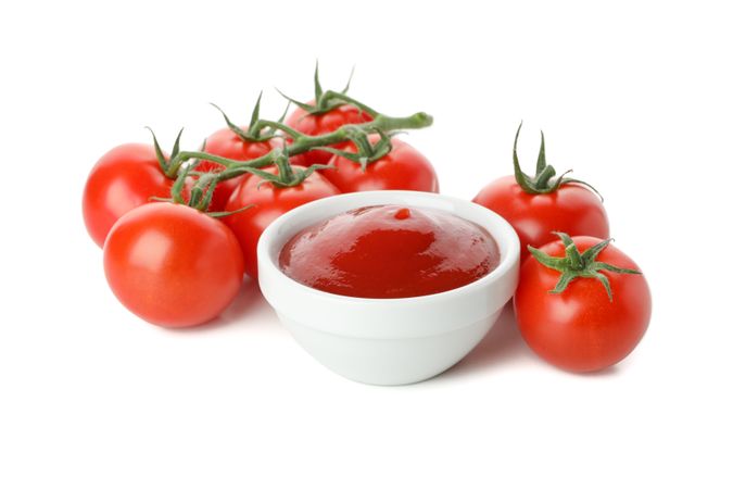 Branch of tomatoes and bowl with sauce isolated on plain background