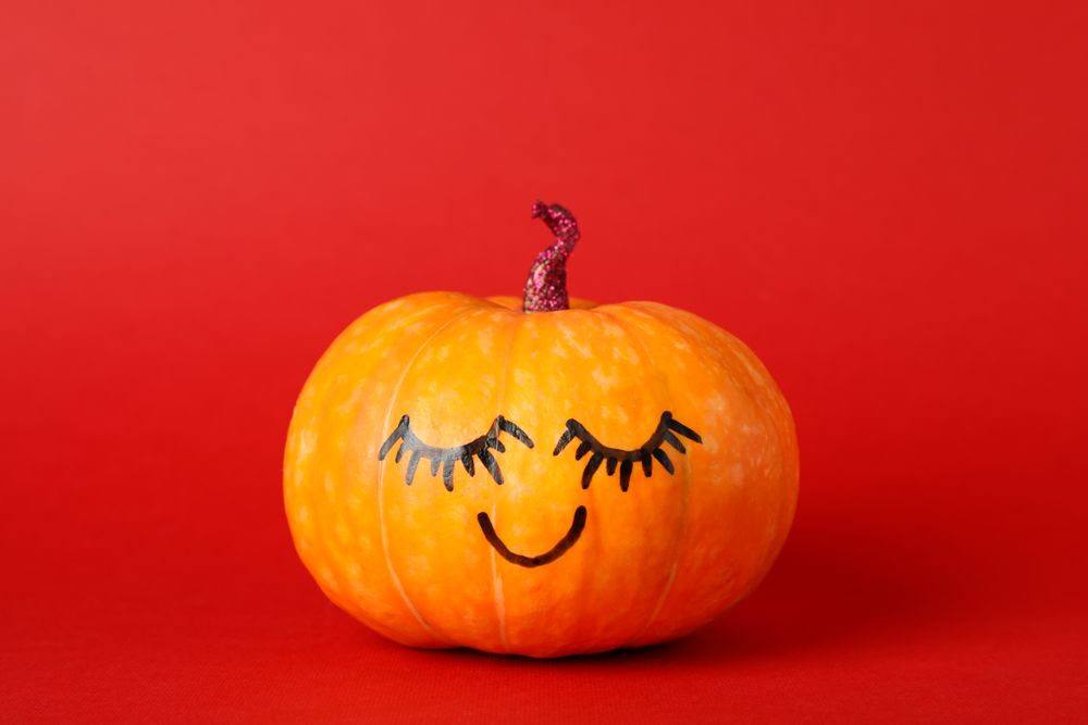Pumpkin with smile on red background, space for text