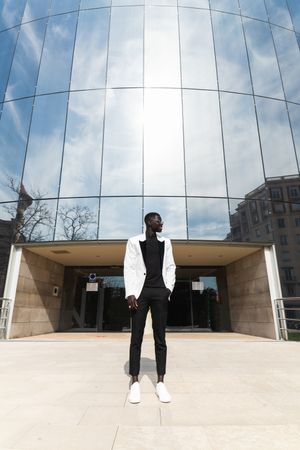 Stylish Black businessman against modern building in city
