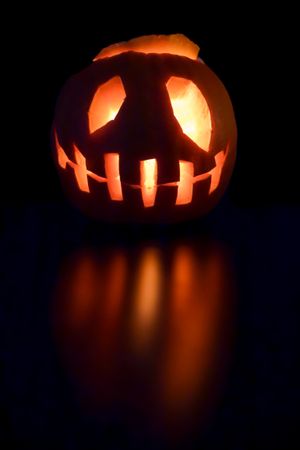 Lit pumpkin Jack-O-Lantern with reflection
