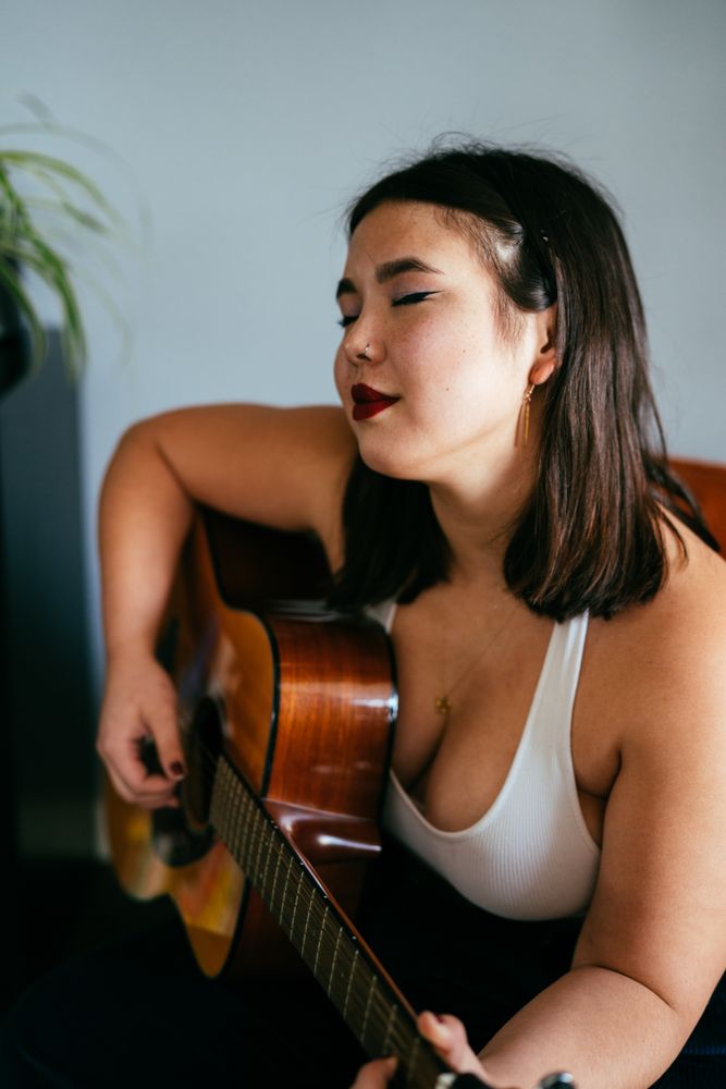 Young woman in repose holding guitar
