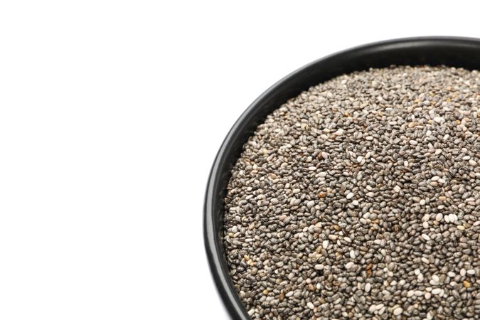 Chia seeds and bowl isolated on studio background