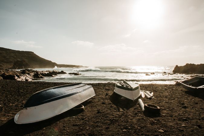 Boats on stony shore near sea
