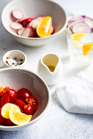 Ingredients of radishes, lemon and cherry tomatoes concrete background