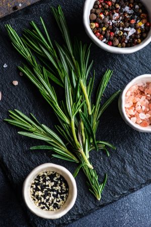 Top view of rosemary sprig on kitchen slab with seasoning