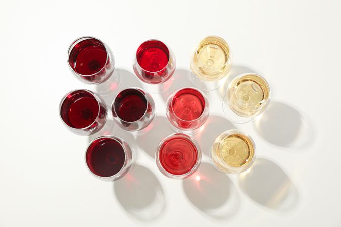 Flat lay composition. Glasses with different wine on blank background, top view