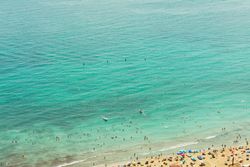 Serene turquoise sea with light waves and beach