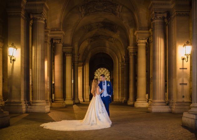 Just married couple in wedding clothing cuddling under moonlight