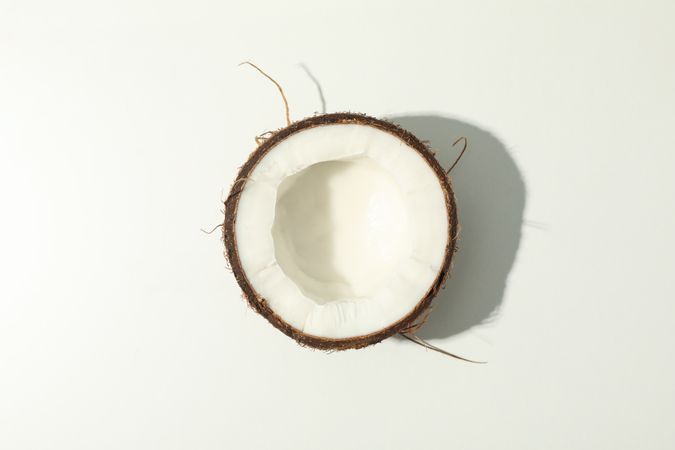 Half of coconut on plain background, top view