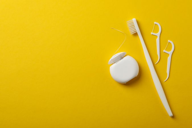 Tools for dental care on yellow background, space for text