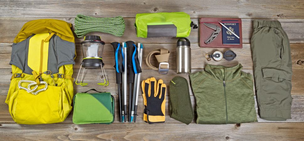 Hiking and camping gear organized on rustic wood
