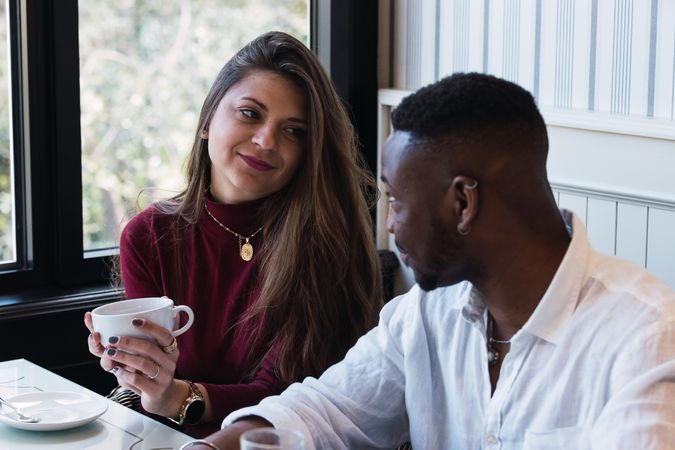 Multiracial couple chatting during breakfast in cafe