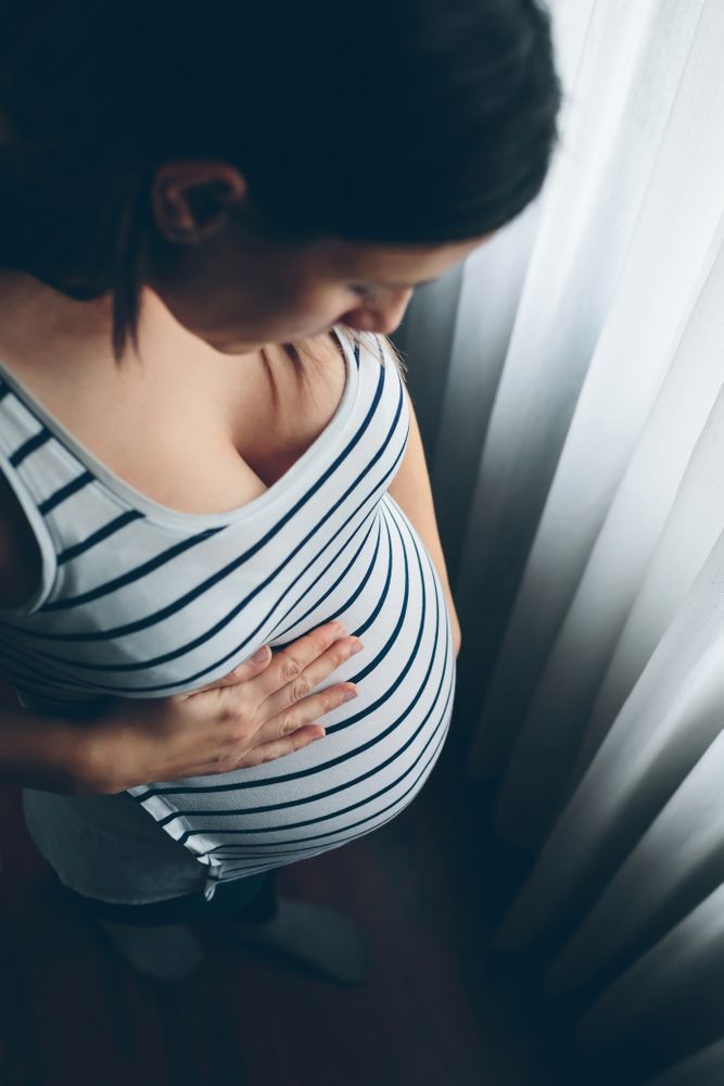 Pregnant woman looking her belly