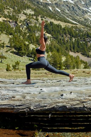 Side view of young woman doing yoga in a valley outside