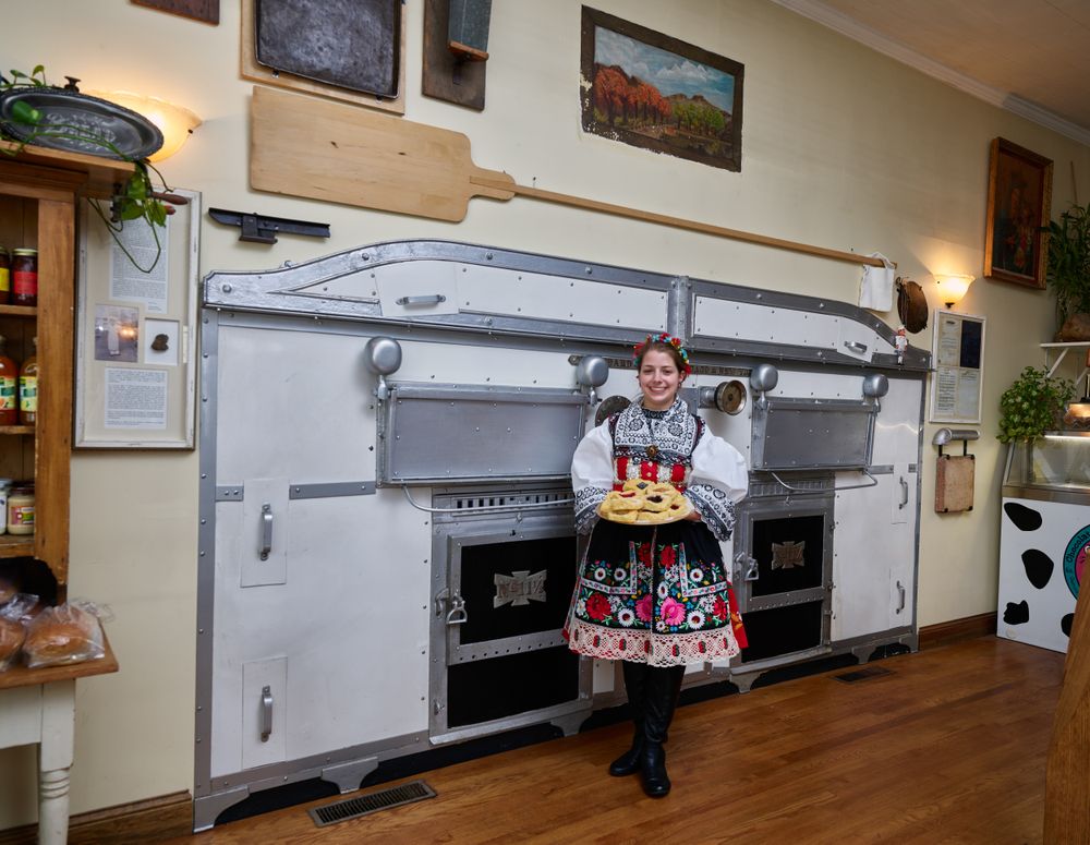 Woman offers a plate of freshly baked Czech pastries at the Sykora Bakery,  Cedar Rapids, Iowa