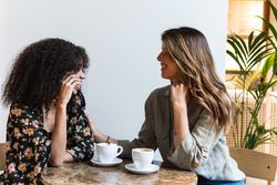 Multiethnic girlfriends with coffee spending time in cafe