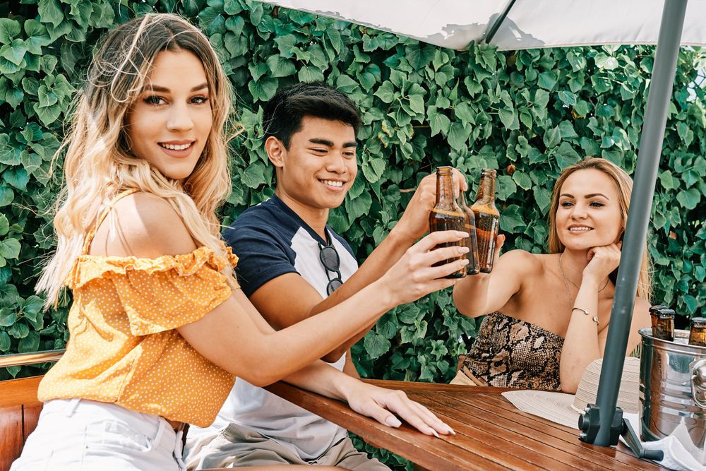 a group of young people cheering with beer in summer