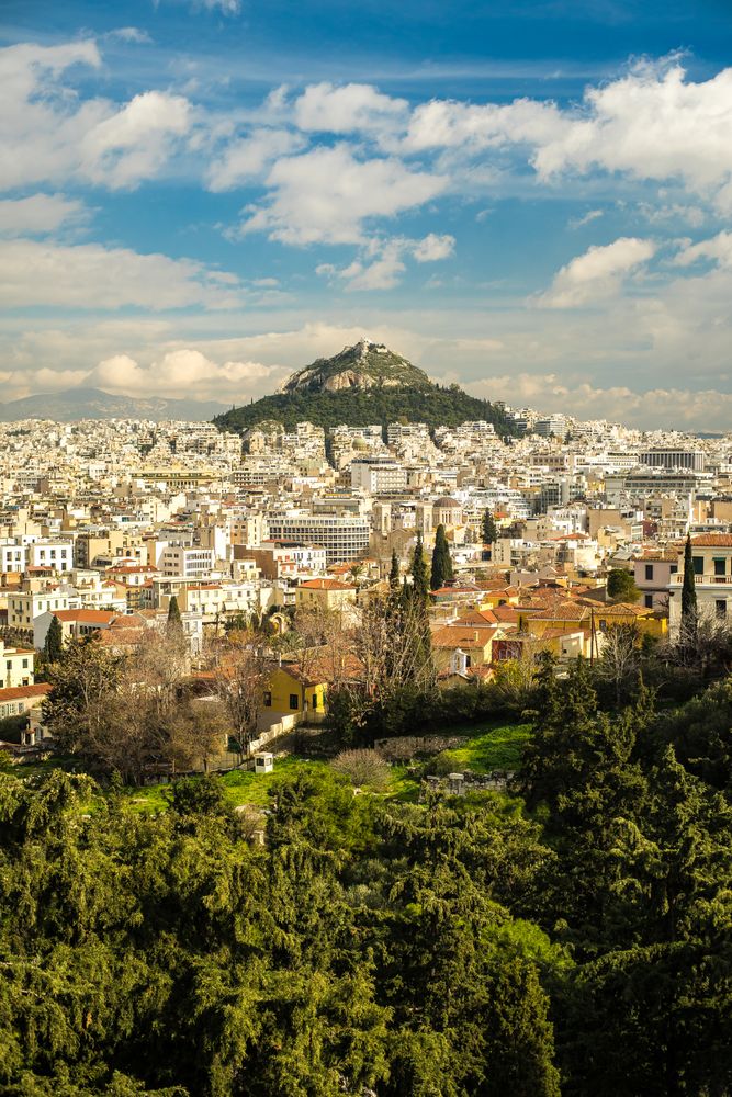 Cloudy sky over city and mountain peak