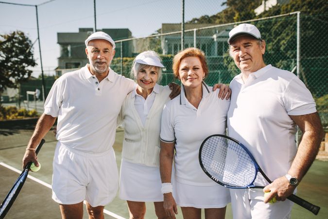 Portrait of older men and women on tennis court