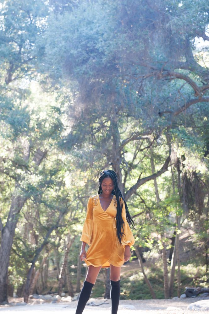 Fashionable woman in short yellow dress and tall black socks in the woods