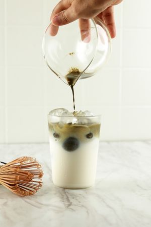 Matcha Tea is Poured in Iced Milk.