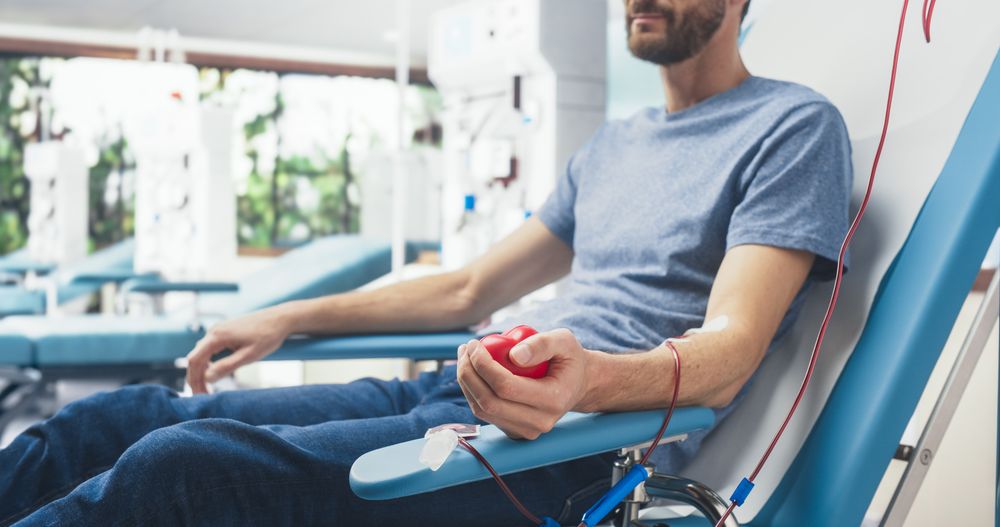 Close Up Shot Of Hand Of Male Blood Donor With an Attached Catheter.