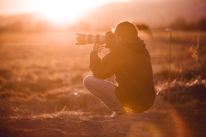 Man shooting on camera beautiful landscape between hills