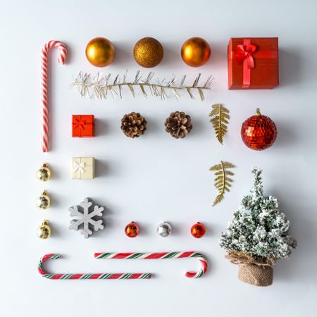 Christmas layout made of festive decorations, baubles, candy canes, presents on light background