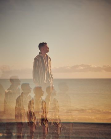 Young man at beach with multiple reflections