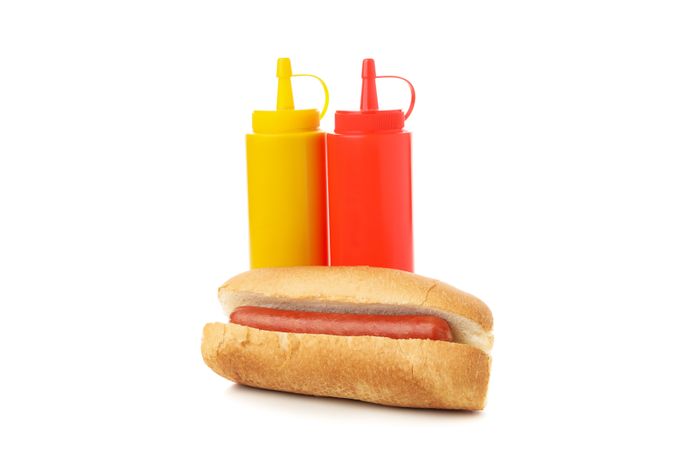 Bun with sausage, mustard and ketchup isolated on plain background