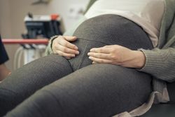 Close-up of a pregnant woman's belly in a medical clinic.
