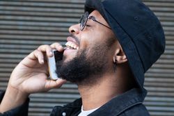Happy hipster man getting good news during phone call