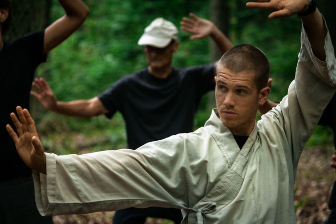 Bald woman practicing martial arts in garden