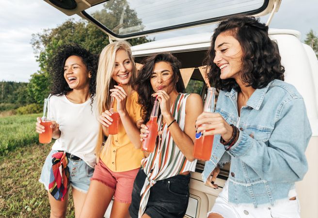 Diverse friends hanging out together in outside of a van