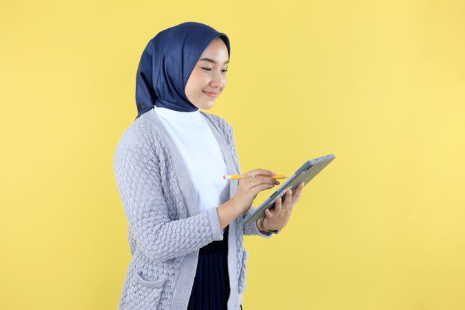 Muslim Asian Young Woman Holding Tablet