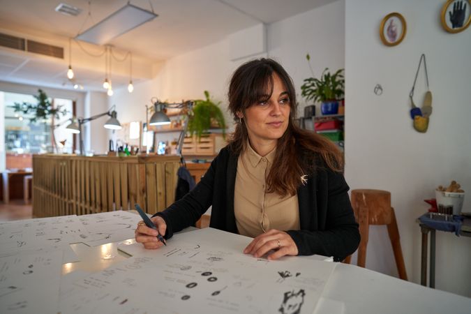 Woman creating sketches of accessories in workshop