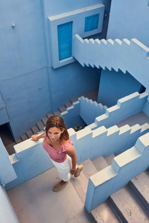 Woman walking downstairs on modern blue building