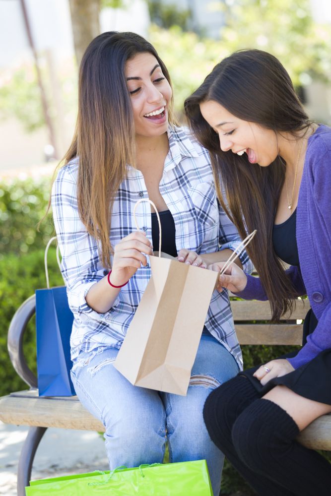 Young Women Looking Into Shopping Bags