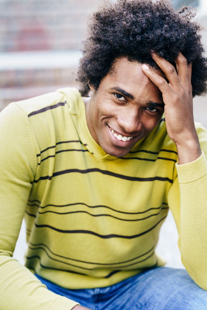 Man smiling and putting his hand through his hair