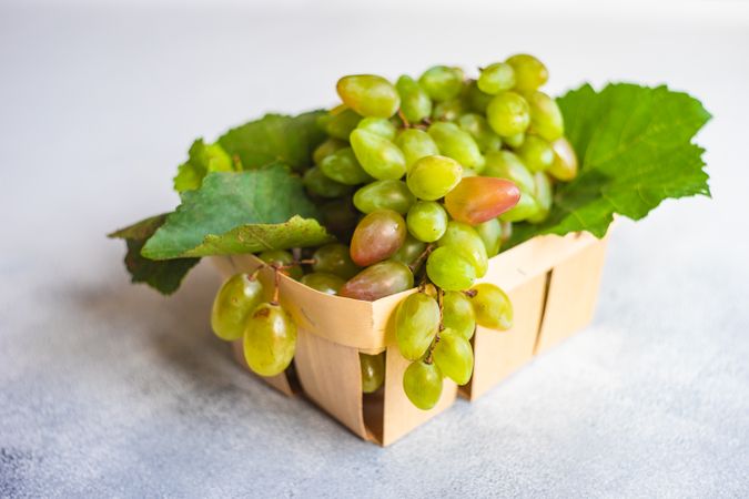 Box of fresh green grapes on kitchen counter