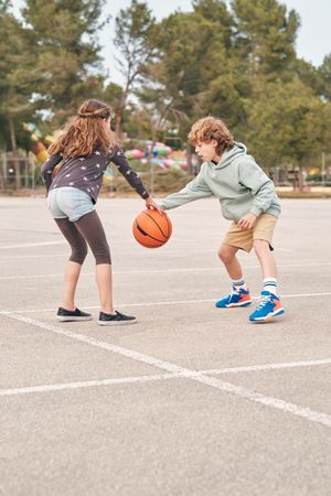 Teen friends playing basketball together