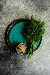 Blue plate with fresh dill on a grey counter