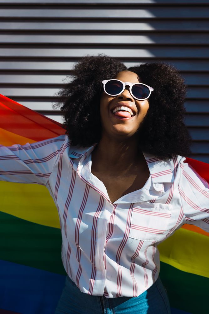 Fun woman posing happily with the LGBT flag