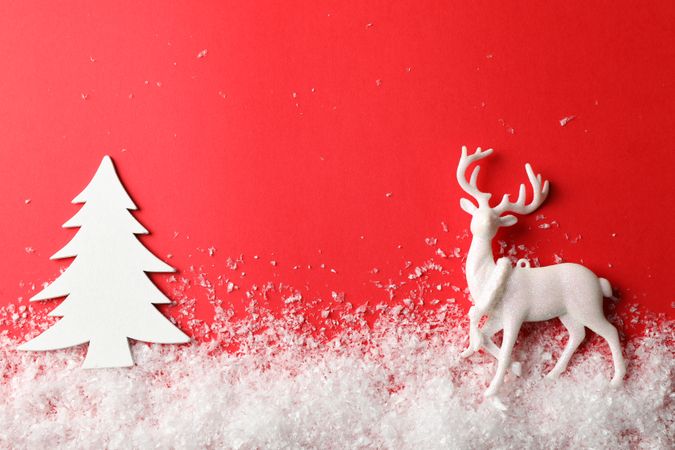 Snow, decorative trees and reindeer on red background, space for text