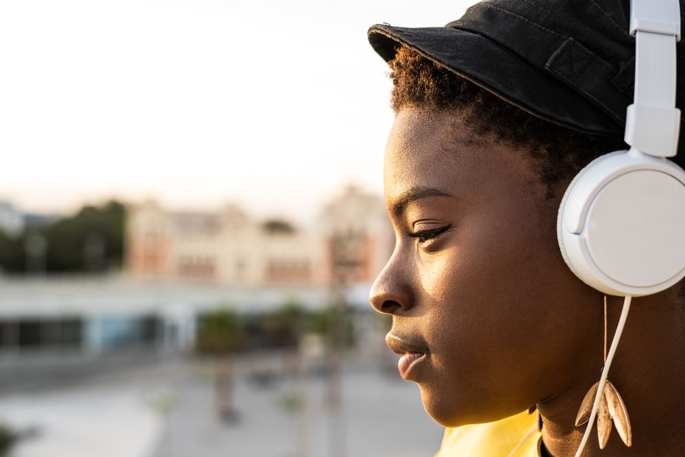 Peaceful female enjoying music and relaxing on balcony