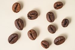 Flat lay of roasted coffee beans scattered on a surface.